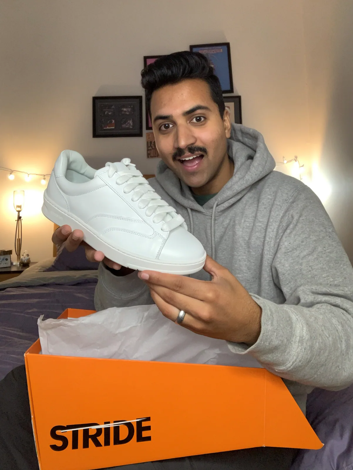 MOSS Image UGC photo of a man unboxing white sneakers from a STRIDE box