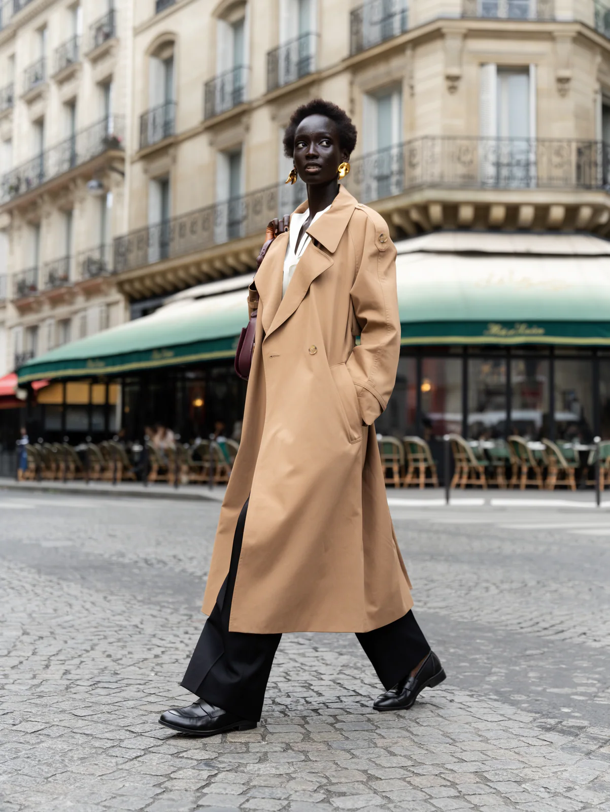 MOSS Image street style photo of a woman in a camel trench coat walking in Paris