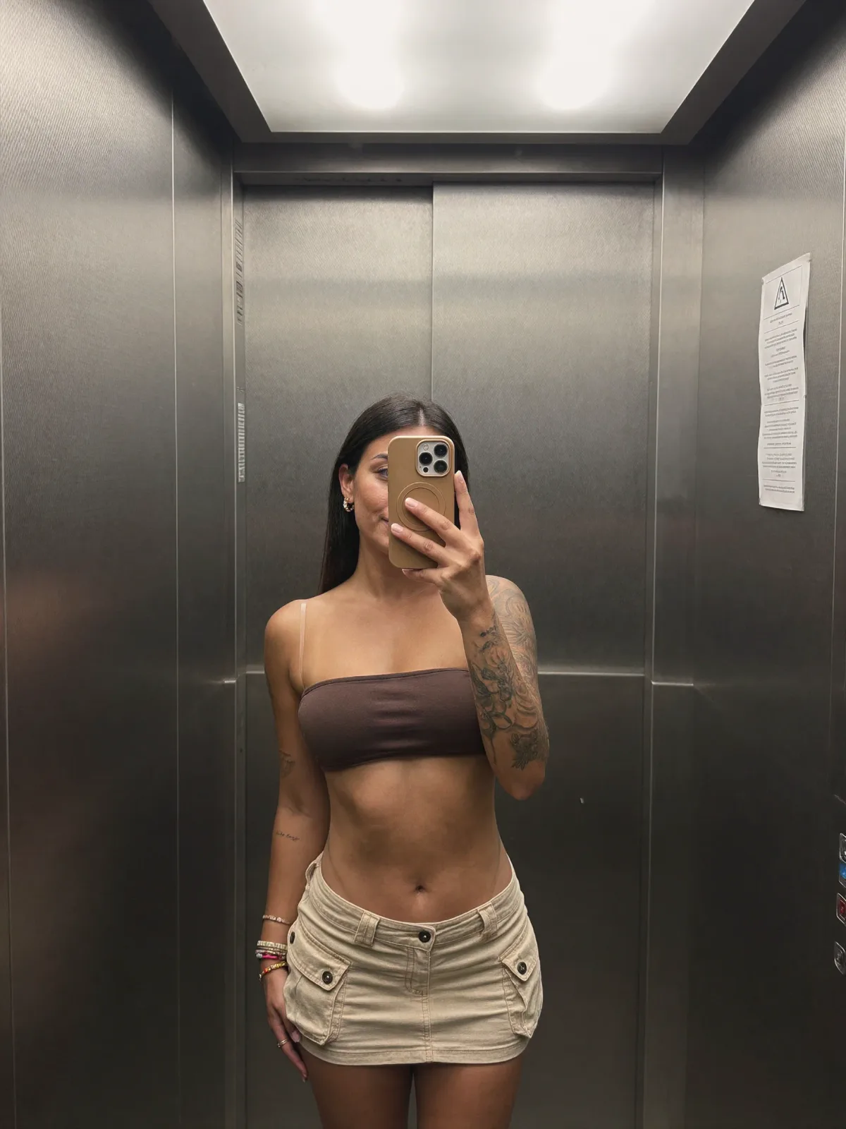 AI photo of a woman with long straight dark hair: bandeau and cargo skirt elevator selfie, made with KREA 2