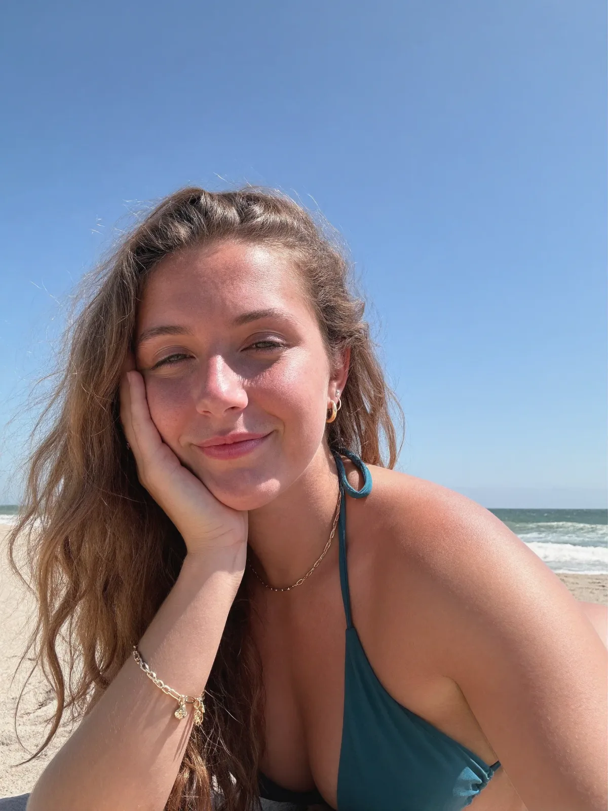 AI photo of a woman with long wavy light-brown hair: beach day selfie in a teal swim top, made with KREA 2