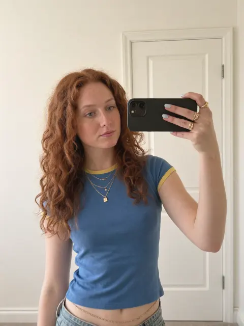 AI photo of a woman with red-auburn hair: blue tee bathroom mirror selfie, made with KREA 2