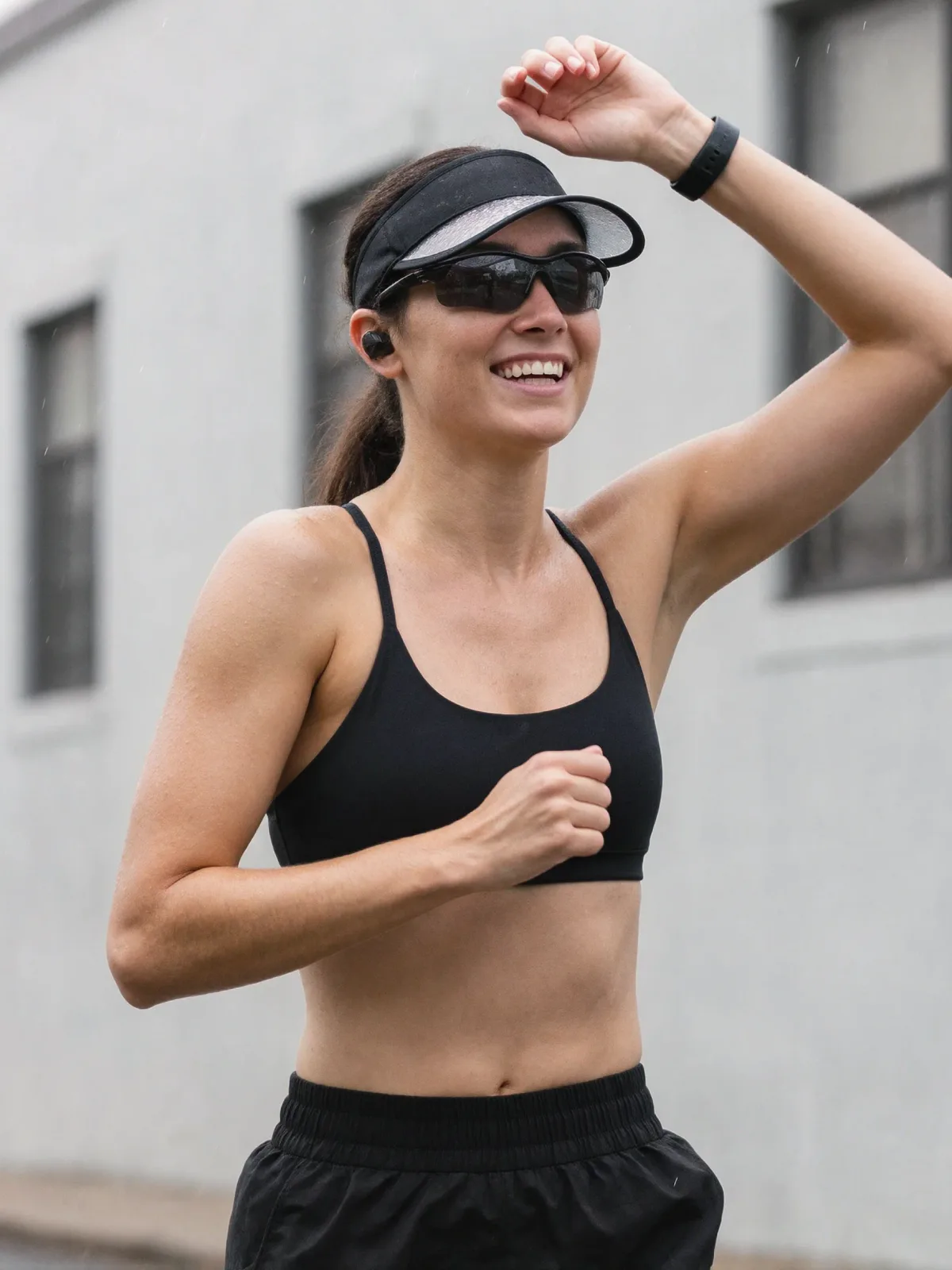 AI photo of a woman with dark wet hair: city run in a sports bra and visor, made with KREA 2