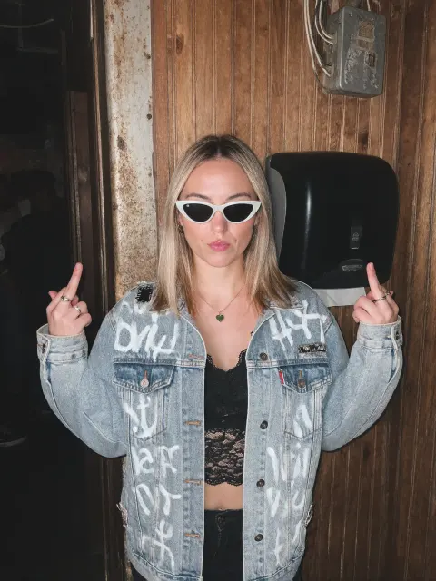 AI photo of a woman with shoulder-length straight blonde hair: denim jacket night attitude shot, made with KREA 2