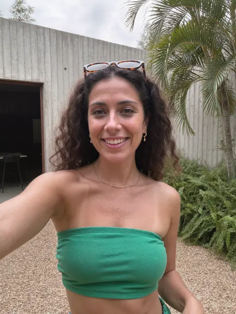 AI photo of a woman with voluminous dark brown curly hair: green bandeau garden selfie, made with KREA 2