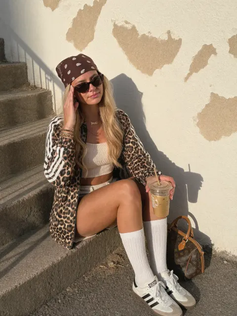 AI photo of a woman with long wavy blonde hair: leopard jacket on outdoor stairs, made with KREA 2