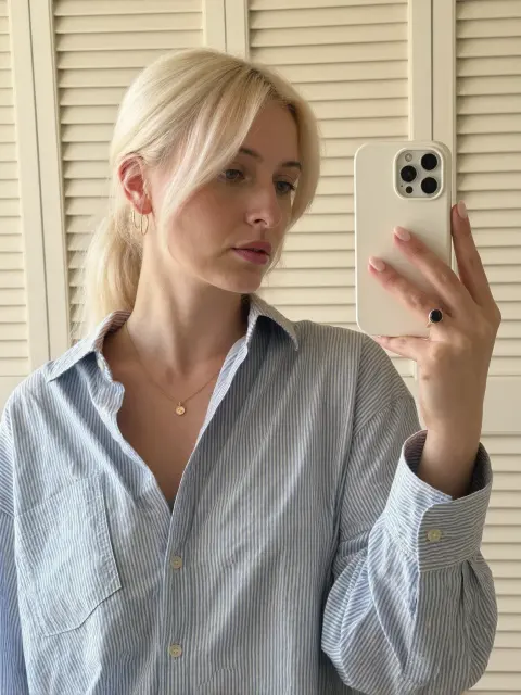 AI photo of a woman with platinum blonde hair: striped shirt mirror selfie, made with KREA 2