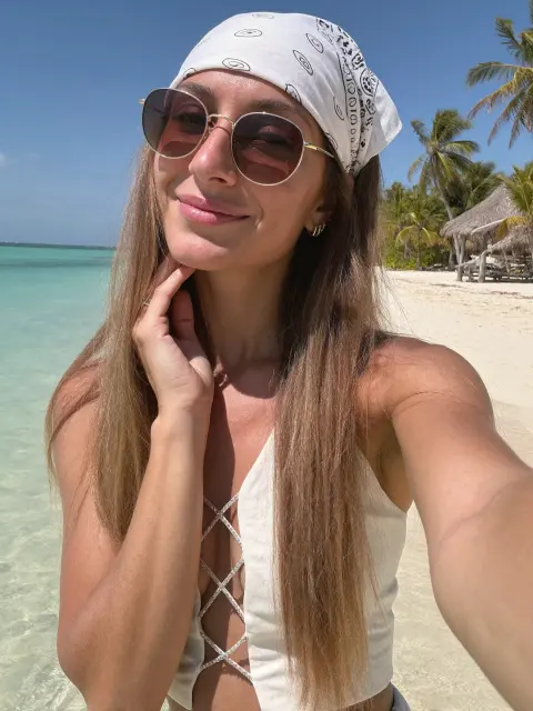 AI photo of a woman with long straight light-brown hair: tropical beach selfie in aviator sunglasses, made with KREA 2